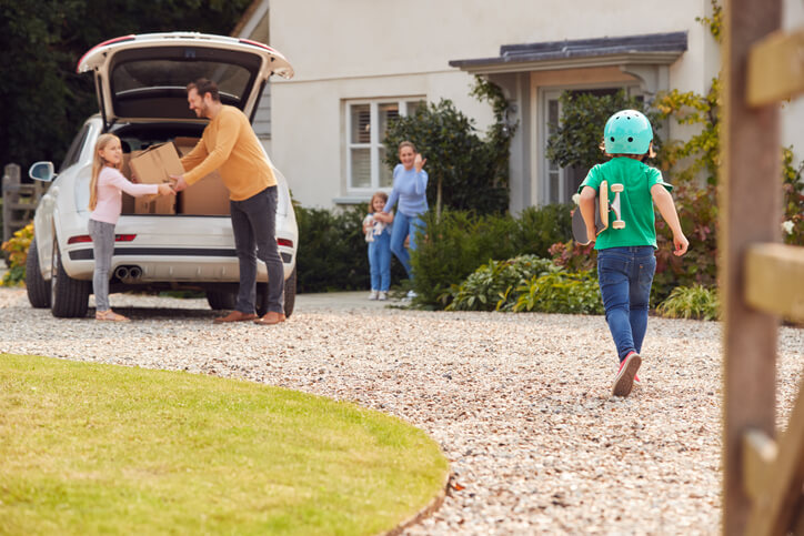 a family with kids moving house and loading up a car