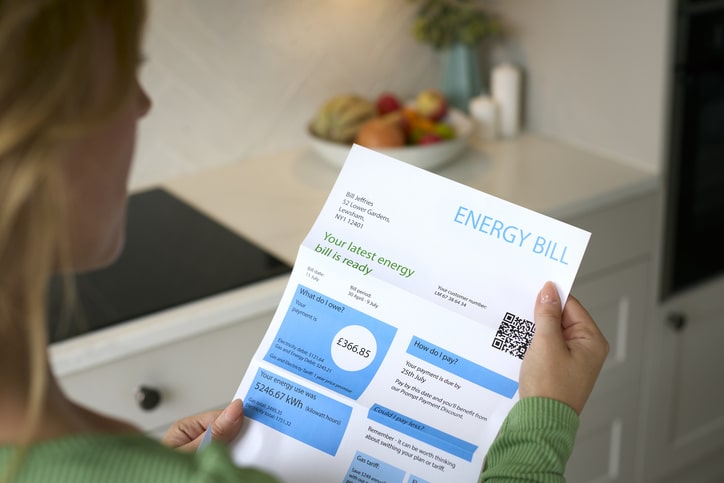 a woman reviewing a UK energy bill at home