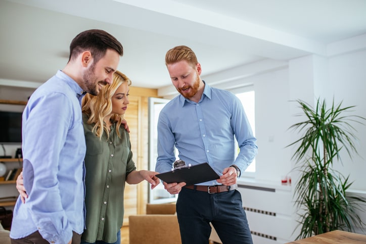 an estate agent completing a house valuation with couple homeowners